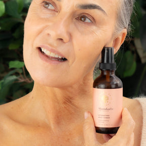 Woman holding bottle of ManukaRx Hydrating Mist Toner